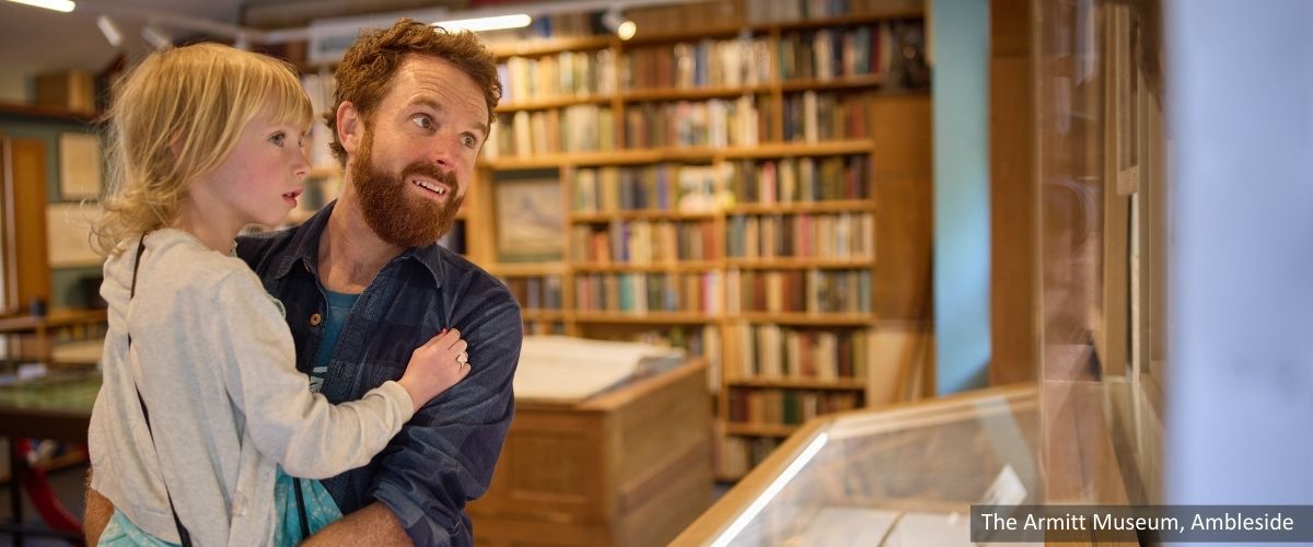 Father and child looking at an exhibition at The Armitt Museum in Ambleside, Lake District